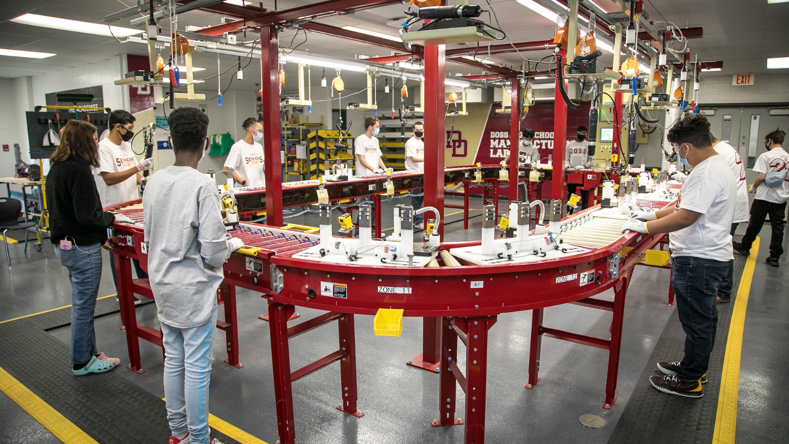 Students stand around test manufacturing line