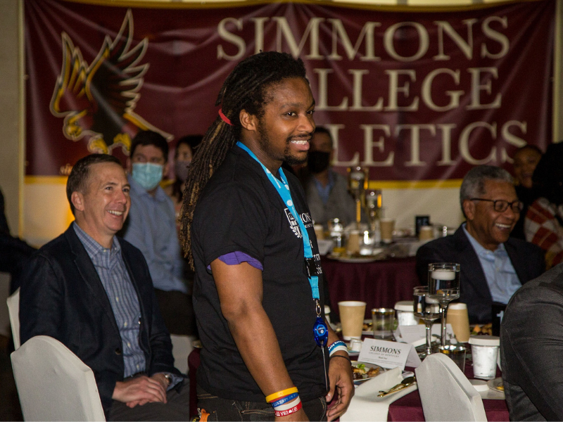 Evan Young poses for a photo at a Simmons College breakfast 